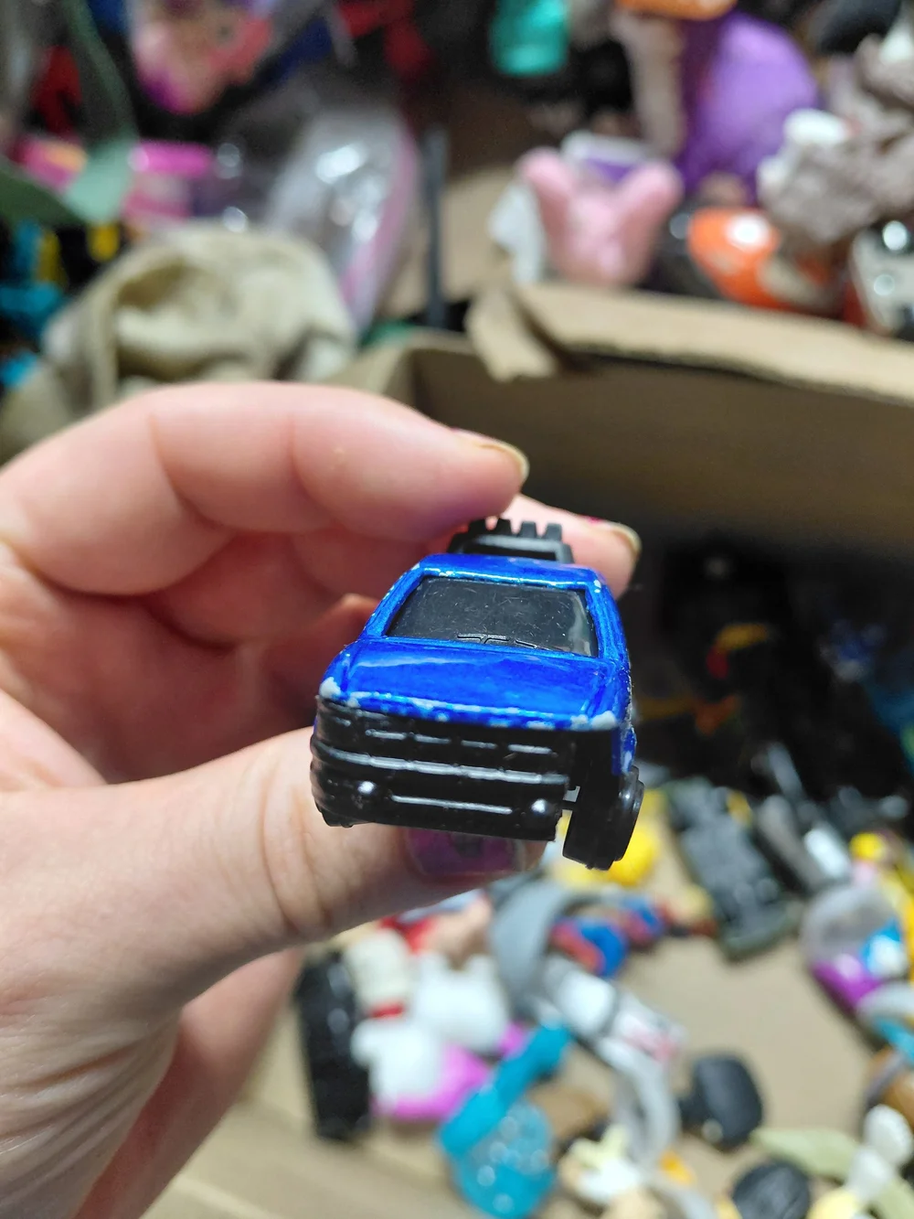 blue diecast pickup truck is a 1:64 scale model, possibly from a 